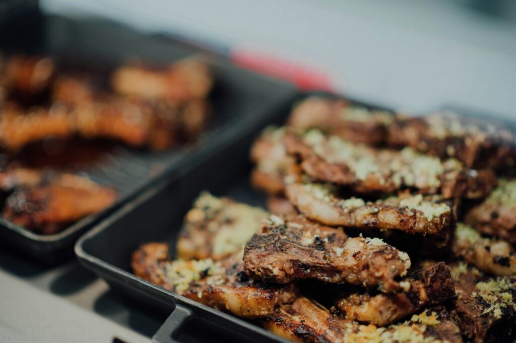 Freshly cooked oven-baked ribs with crispy edges and rich barbecue glaze on a serving platter.